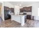 An open kitchen with dark cabinets, stainless steel appliances, and an island with marble countertops at 5677 Starla Ln, Plainfield, IN 46168