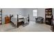 Bedroom features a metal bed frame, dresser, bookcase, and comfortable seating area near a bright window at 2856 Jamieson Ln, Indianapolis, IN 46268