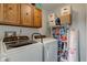 Bright laundry room with washer, dryer, storage, and oak cabinets at 2856 Jamieson Ln, Indianapolis, IN 46268