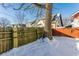 Snowy backyard with wooden fence and large tree in winter at 5009 E Michigan E St, Indianapolis, IN 46201