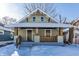 Charming craftsman bungalow with a covered porch and snow-covered lawn at 5009 E Michigan E St, Indianapolis, IN 46201