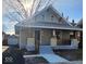 Light green craftsman home with a covered porch and detached garage at 5009 E Michigan E St, Indianapolis, IN 46201