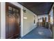 Renovated front porch with dark brown door and gray flooring at 5009 E Michigan E St, Indianapolis, IN 46201