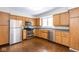 Well-lit kitchen features stainless steel appliances and ample wood cabinetry with tile floors at 7027 Creekside Ln, Indianapolis, IN 46220