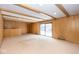 Spacious living room featuring a brick fireplace, wet bar, wood paneling and carpet floors at 7027 Creekside Ln, Indianapolis, IN 46220