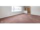 Spacious living room area with large windows and carpet flooring at 7027 Creekside Ln, Indianapolis, IN 46220