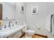 Bright bathroom with a pedestal sink, toilet, mirror, and neutral walls at 3592 W Smokey Row Rd, Bargersville, IN 46106