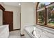 Bathroom with a soaking tub under an arch window, a shower, and natural light at 3592 W Smokey Row Rd, Bargersville, IN 46106
