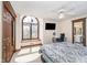 Bedroom with neutral carpet, a ceiling fan, large arched window, desk, and access to a bathroom at 3592 W Smokey Row Rd, Bargersville, IN 46106
