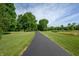 Scenic driveway framed by lush trees leading towards a tranquil pond at 3592 W Smokey Row Rd, Bargersville, IN 46106