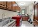 Functional laundry room with updated cabinets, a sink, and a modern red washer and dryer at 3592 W Smokey Row Rd, Bargersville, IN 46106