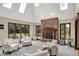 Bright living room with skylights features a brick fireplace, multiple chairs, and views of the backyard at 3592 W Smokey Row Rd, Bargersville, IN 46106
