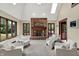 Bright living room features a brick fireplace, multiple chairs, views of the backyard, and skylights at 3592 W Smokey Row Rd, Bargersville, IN 46106