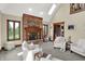 Bright living room features a brick fireplace, multiple chairs, views of the backyard, and skylights at 3592 W Smokey Row Rd, Bargersville, IN 46106