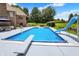 Backyard swimming pool with diving board, slide, and lounge area near pond at 3592 W Smokey Row Rd, Bargersville, IN 46106