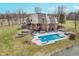 Aerial view showcasing a pool with a slide and hot tub, surrounded by outdoor seating, lush greenery, and a tranquil pond at 3592 W Smokey Row Rd, Bargersville, IN 46106