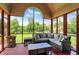 Screened porch with red deck, gray outdoor furniture, and views of the backyard at 3592 W Smokey Row Rd, Bargersville, IN 46106
