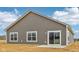 Gray single-story home with white trim, large windows, and a sliding glass door to the backyard at 113 Luna Pl, Shelbyville, IN 46176