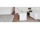 Bright kitchen with stainless steel appliances, center island, white cabinets, and wood flooring at 113 Luna Pl, Shelbyville, IN 46176