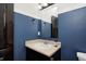 Small bathroom with a vanity, sink, and toilet. Features blue walls and dark wood accents at 2959 Hearthside Dr, Greenwood, IN 46143