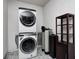 Laundry room with stackable washer and dryer, water softener, and shelving at 2959 Hearthside Dr, Greenwood, IN 46143