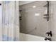 Bathroom with shower/tub combo, grey wall surround, and linen shelves at 4522 Thornleigh Dr, Indianapolis, IN 46226
