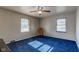 Spacious bedroom with blue carpet, ceiling fan, and two windows at 4522 Thornleigh Dr, Indianapolis, IN 46226