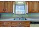 Kitchen with stainless steel sink, wood cabinets, and a bright window at 4522 Thornleigh Dr, Indianapolis, IN 46226