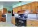 Classic kitchen with wood cabinets, black appliances, and a light green color scheme at 4522 Thornleigh Dr, Indianapolis, IN 46226