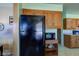 Black refrigerator in kitchen with wood cabinets and microwave at 4522 Thornleigh Dr, Indianapolis, IN 46226