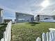 Exterior shot of a home's spacious backyard featuring a lush lawn, white picket fence, and recreational equipment at 5128 Macaferty St, Plainfield, IN 46168