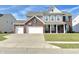 Charming two-story home featuring a brick and siding facade, attached three-car garage, and well-manicured lawn at 5128 Macaferty St, Plainfield, IN 46168