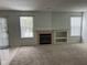Cozy living room featuring a fireplace, built-in shelving, and bright windows, creating a comfortable living space at 6442 E Flat Rock Dr, Camby, IN 46113