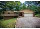 Lovely brick home featuring a front balcony, red door, and attached garage, set in a wooded area at 797 S Graveyard Rd, Paragon, IN 46166