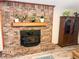 Close up of brick fireplace with wood mantel and wood-burning stove, accented with plants and decor at 797 S Graveyard Rd, Paragon, IN 46166