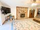 Spacious living room featuring a brick fireplace, ceiling fan, and large rug, perfect for relaxation at 797 S Graveyard Rd, Paragon, IN 46166