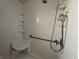All-white tiled shower featuring built-in seat, grab bar, and toiletry caddy at 801 Spring Valley Dr, Indianapolis, IN 46231