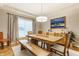 Bright dining room with a wooden table, bench seating, modern lighting, and contemporary artwork at 10866 Flower Mound Pl, Fishers, IN 46037