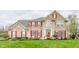 Charming brick two-story home with red shutters and well-manicured lawn, offering classic curb appeal at 10866 Flower Mound Pl, Fishers, IN 46037