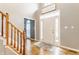 Bright foyer featuring hardwood floors, a staircase, and a 'Let's Stay Home' decor sign at 10866 Flower Mound Pl, Fishers, IN 46037