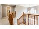 Open hallway with wooden banisters and a view of the foyer's chandelier, highlighting the home's layout at 10866 Flower Mound Pl, Fishers, IN 46037