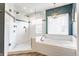 Stunning bathroom featuring a glass shower, soaking tub, and elegant lighting fixtures at 10866 Flower Mound Pl, Fishers, IN 46037