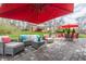 Beautiful stone patio with stylish seating, a red umbrella, and an outdoor dining area for entertaining at 10866 Flower Mound Pl, Fishers, IN 46037