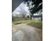 Fenced backyard featuring a concrete patio, storage building and mature trees at 2521 Prospect St, Indianapolis, IN 46203