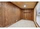 Cozy room featuring wood-paneled walls, carpeted floor, and a window offering natural light at 2521 Prospect St, Indianapolis, IN 46203
