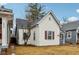 Home featuring white siding, red window trim, gray roof, and manicured yard at 2521 Prospect St, Indianapolis, IN 46203