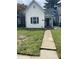 Charming home with white siding, neat front yard and a concrete walkway leading to the front door at 2521 Prospect St, Indianapolis, IN 46203