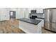 Bright kitchen featuring a black island, stainless steel appliances, and modern backsplash at 2521 Prospect St, Indianapolis, IN 46203