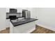 Bright kitchen featuring a black island, stainless steel appliances, and modern backsplash at 2521 Prospect St, Indianapolis, IN 46203