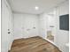 Bright laundry area with wood floors, white walls, and connections for washer and dryer at 2521 Prospect St, Indianapolis, IN 46203